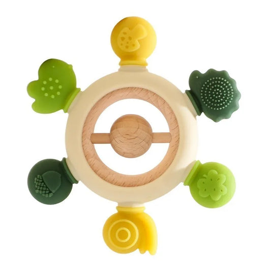 A natural wooden teething rattle featuring five silicone charms in green and yellow hues, shaped like leaves, flowers, and a snail. The center includes a rotating wooden piece for added sensory stimulation. Designed for teething relief and playtime engagement for babies.