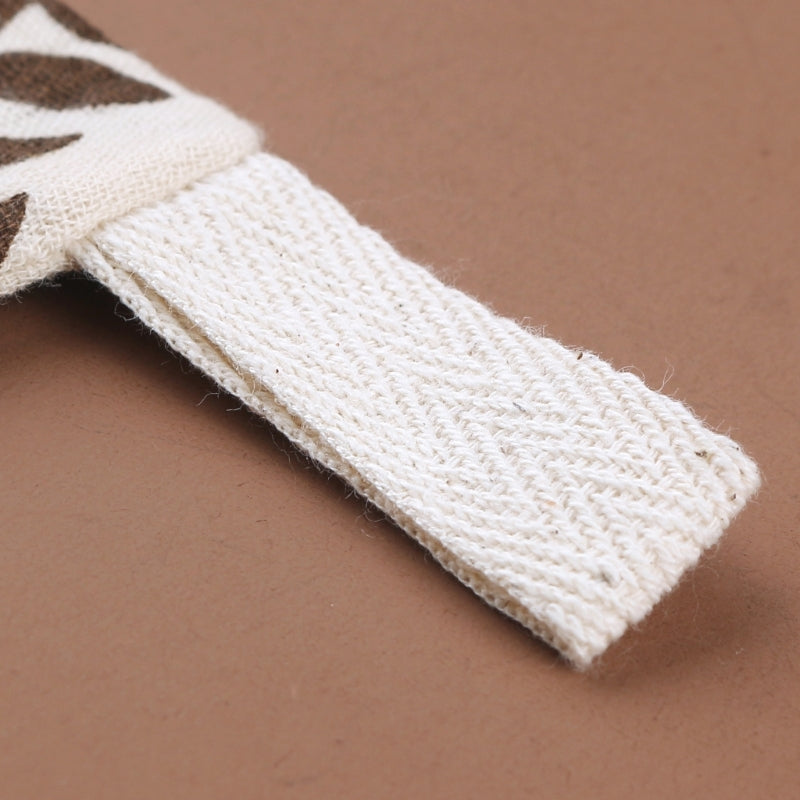 Macro view of cream baby towel texture showing detailed diamond-pattern weave and plush cotton construction, photographed at an angle on warm beige background to highlight the premium fabric quality