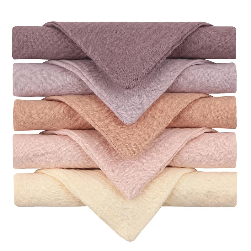 Collection of quilted baby towels in elegant mauve and neutral tones, featuring a gradient from deep mauve to soft pink, peachy beige, and cream, each towel showcasing a diamond-textured pattern perfect for gentle baby skincare