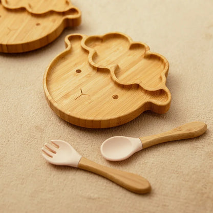 Bamboo sheep-shaped baby plate paired with a wooden spoon and fork featuring soft pink silicone tips, designed for safe and enjoyable toddler meals and baby-led weaning.