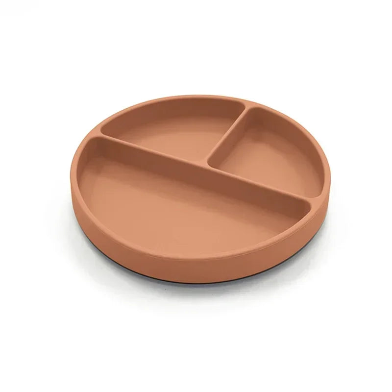 Terra-cotta-colored silicone divided plate with three compartments, designed for toddler meals, portion control, and easy cleaning, ideal for baby-led weaning and mealtime independence.