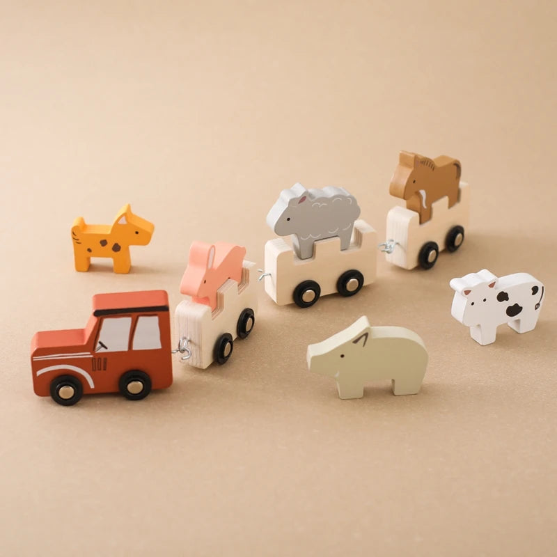 Montessori-style wooden safari animal train set featuring a red locomotive leading interconnected natural wood carriages, each carrying unique animal figures including orange giraffe, coral fox, grey elephant, and brown horse, with additional spotted cow and polar bear figures, arranged against a warm beige background for a clean product display