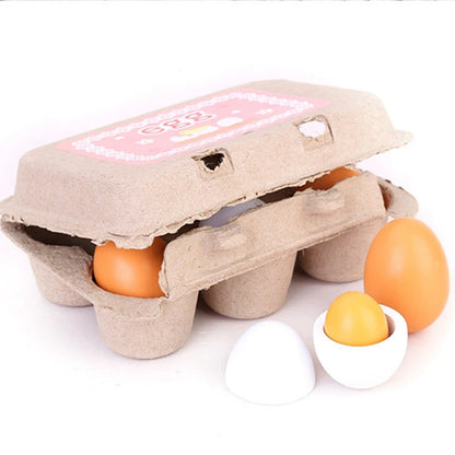 A pretend playset of six wooden eggs in a realistic cardboard carton, featuring two colors (brown and white), with one egg cracked open revealing a yellow yolk.